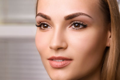 Femme aux sourcils parfait grâce au maquillage permanent par dermopigmentation